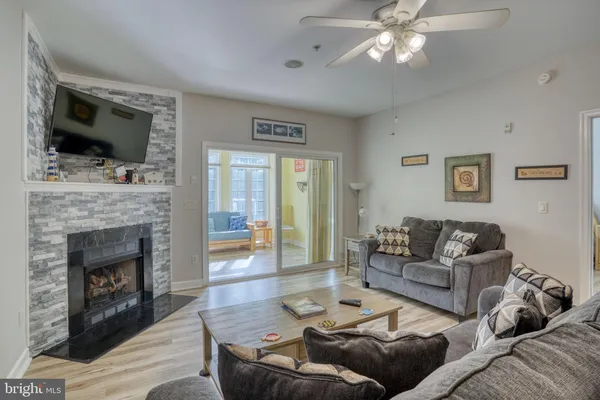 a living room with furniture a flat screen tv and a fireplace