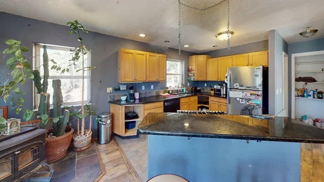 a kitchen with stainless steel appliances granite countertop sink stove and wooden cabinets