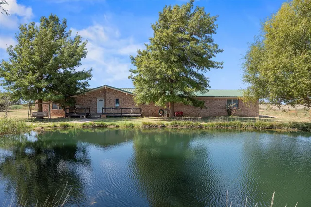 a view of a house with pool and a yard
