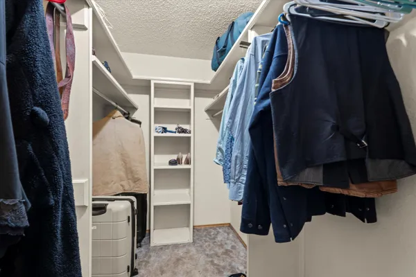 a view of walk in closet with clothes and shoes