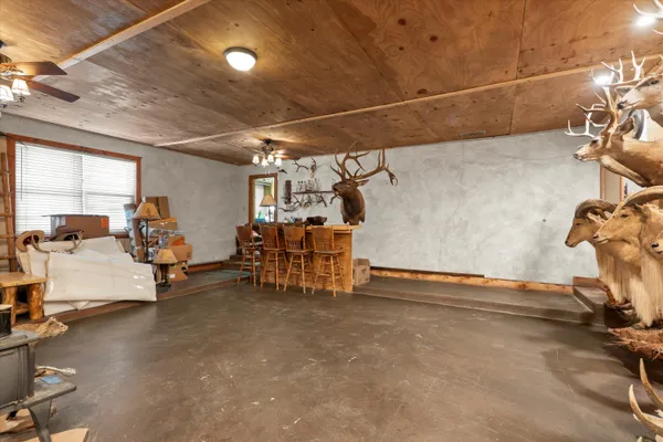 a view of a patio with table and chairs under an umbrella with a large tree