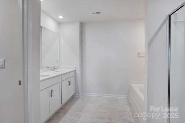 a bathroom with a double vanity sink and mirror