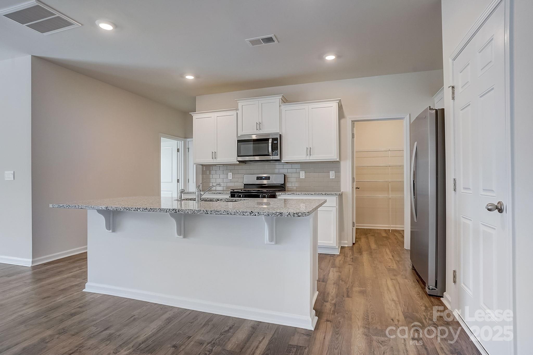 142 Old Home Road Statesville, NC 28677 - Photo 4 of 23 a kitchen with stainless steel appliances a refrigerator a stove a sink and a microwave