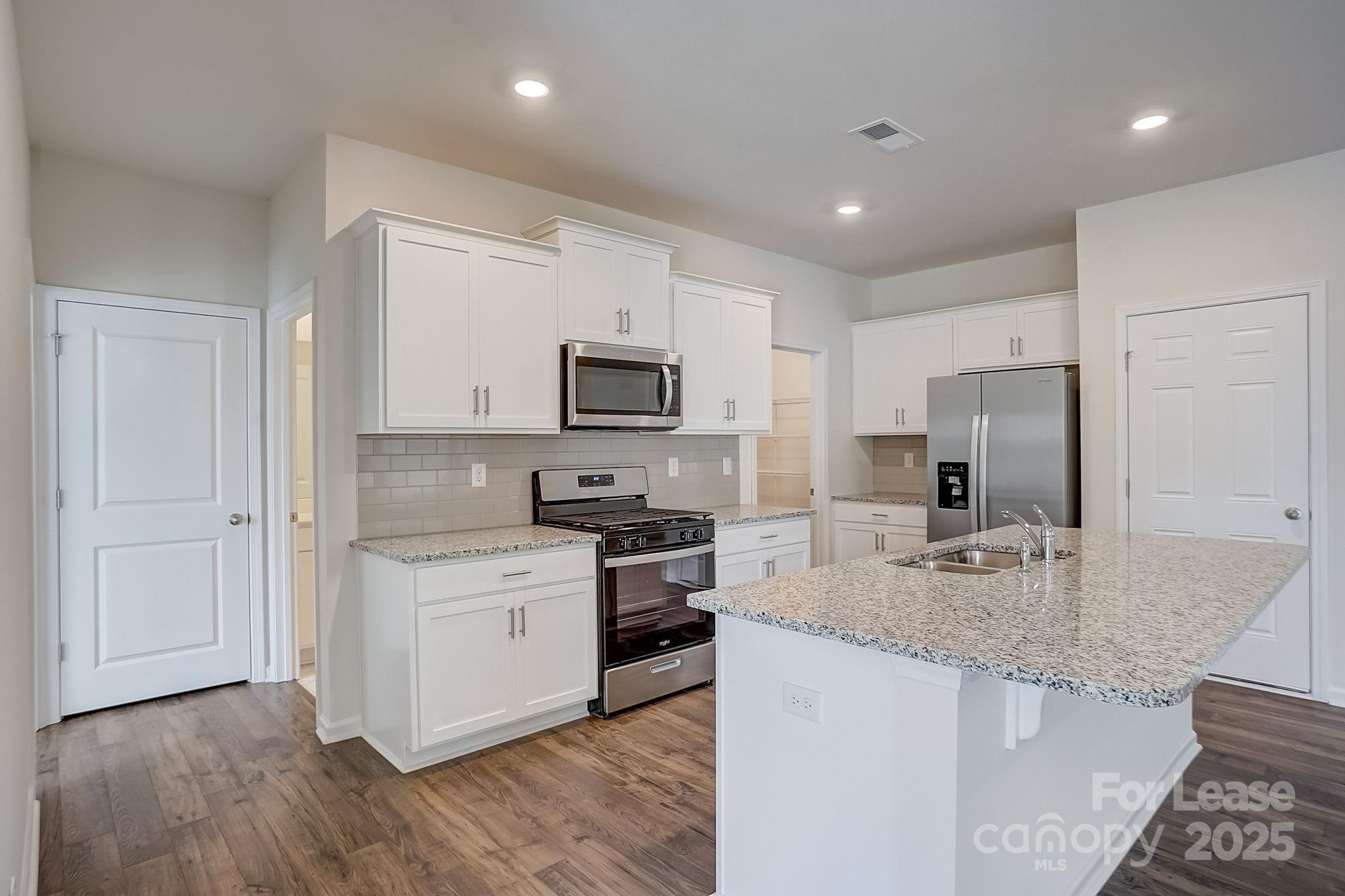 142 Old Home Road Statesville, NC 28677 - Photo 6 of 23 a kitchen with stainless steel appliances granite countertop a stove top oven a sink and a refrigerator