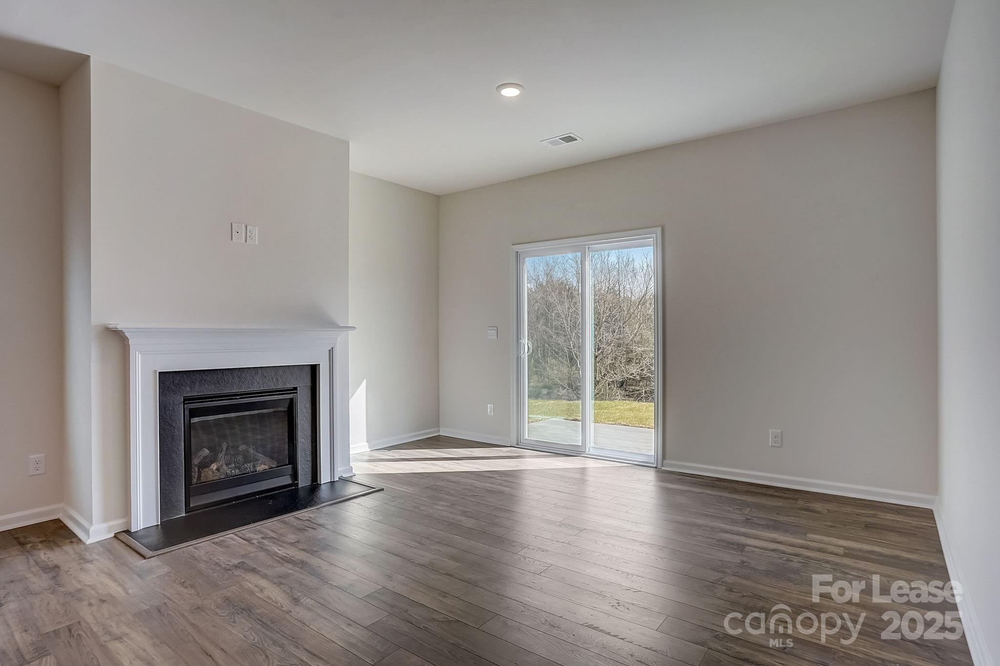 142 Old Home Road Statesville, NC 28677 - Photo 10 of 23 a view of an empty room with wooden floor fireplace and a window