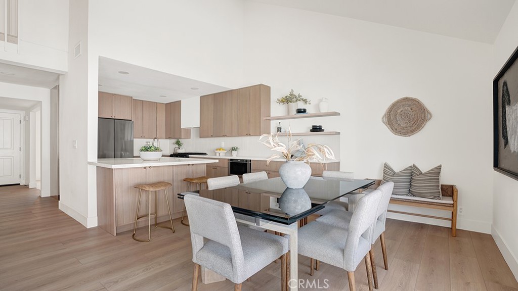 a kitchen with a dining table chairs and white cabinets