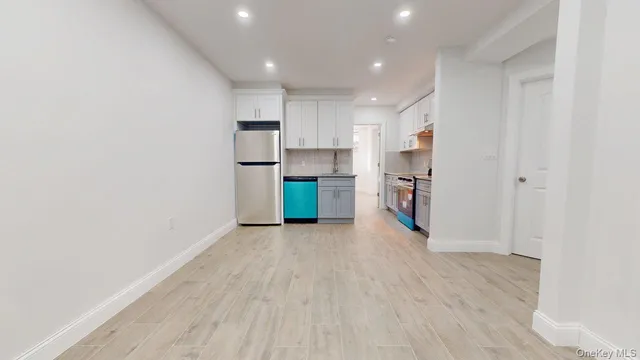 a view of a kitchen with a sink and a refrigerator