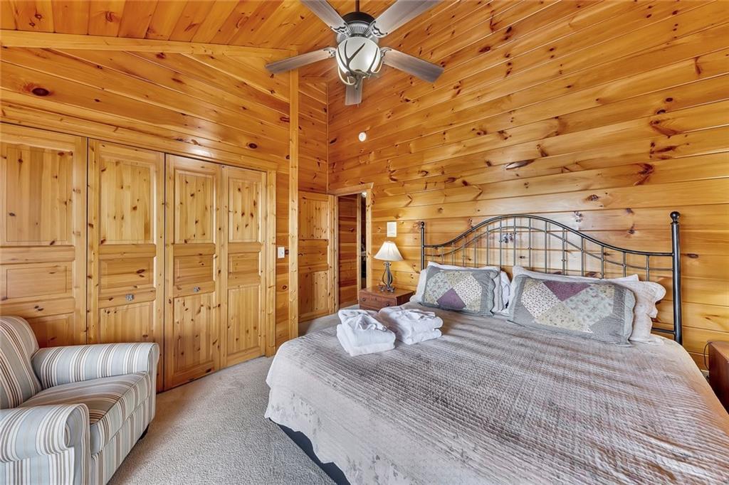 499 Raven Ridge Circle Mineral Bluff, GA 30559 - Photo 18 of 43 a bedroom with a bed a couch and chandelier