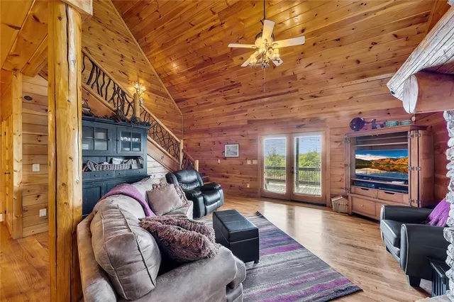 a living room with furniture a flat screen tv and a floor to ceiling window