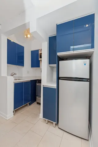 a view of a hallway to a room with wooden floor and chandelier