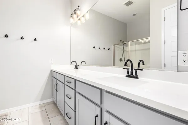 a spacious bathroom with a double vanity sink and a mirror