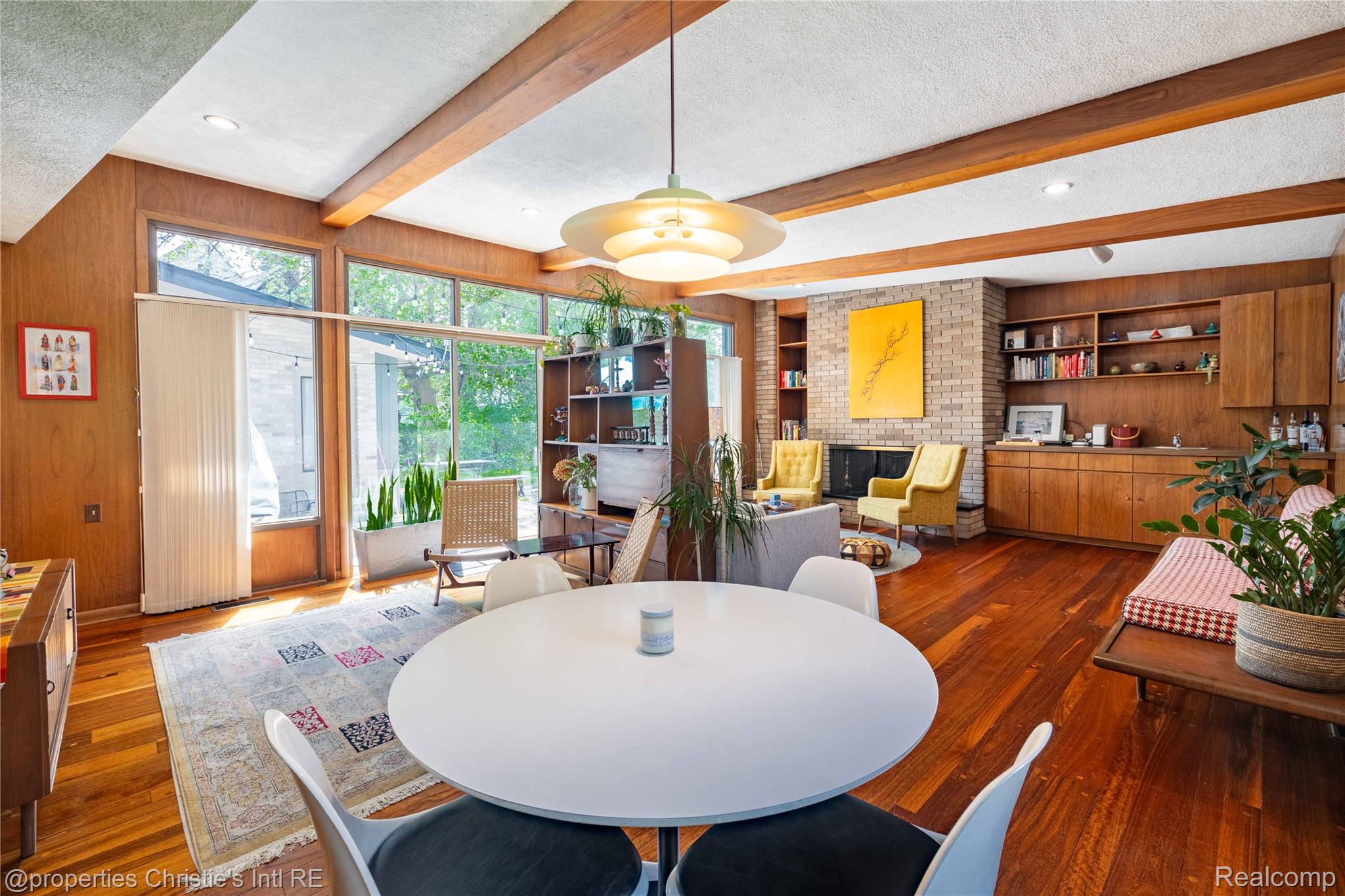 2771 West Seven Mile Road Detroit, MI 48221 - Photo 12 of 57 Open-concept living area featuring rich wood-finish flooring, exposed ceiling beams, and extensive built-in shelving