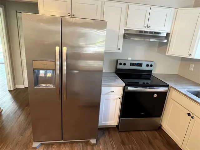 a kitchen with stainless steel appliances granite countertop a refrigerator and a cabinets