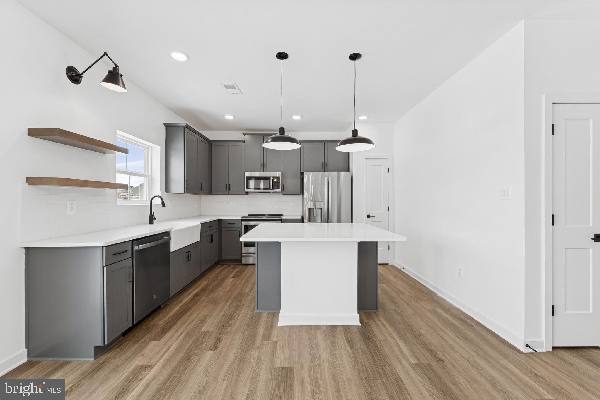 a kitchen with kitchen island a sink and wooden floor