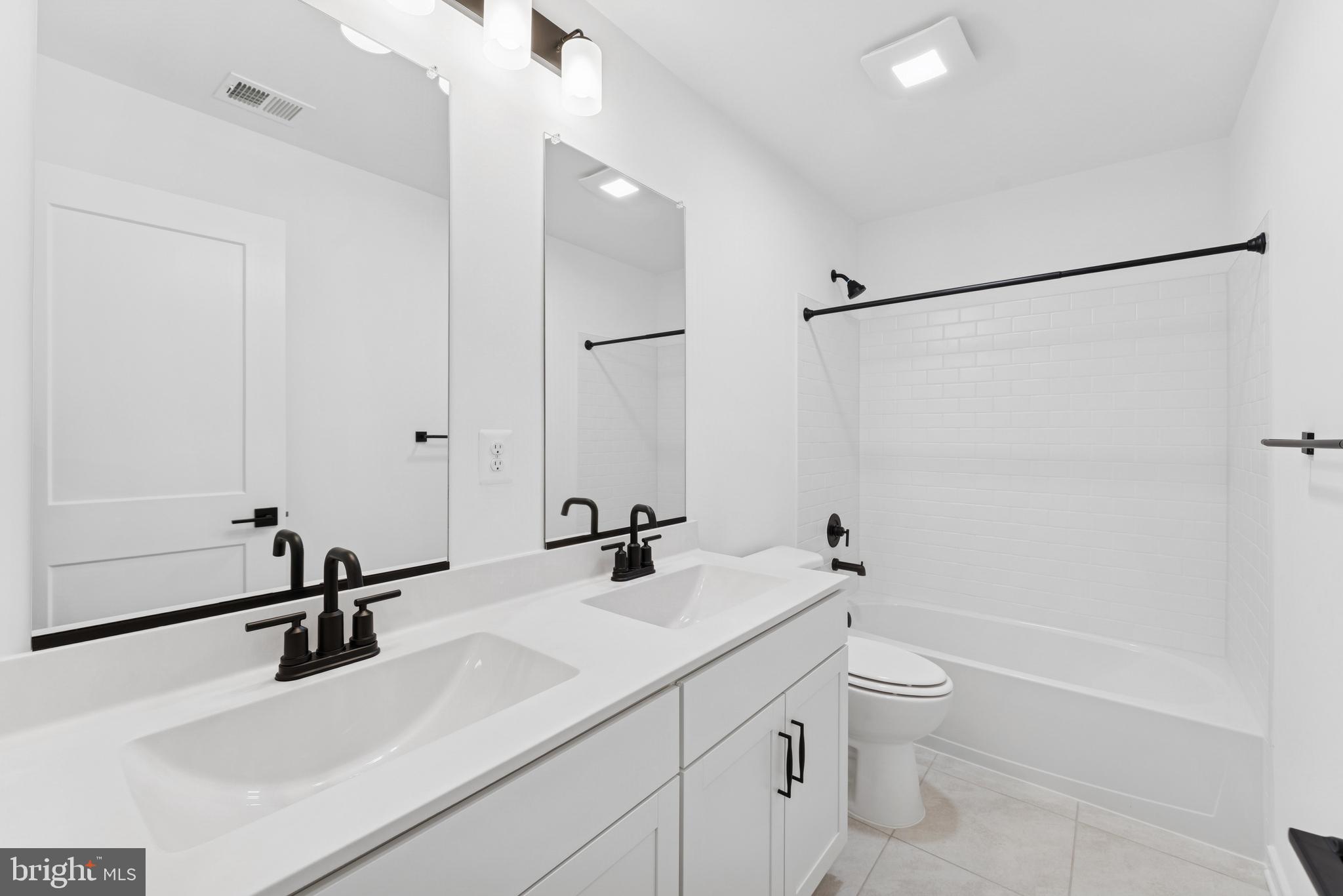 94 Thornton Avenue Ranson, WV 25438 - Photo 12 of 22 a bathroom with a double vanity sink toilet mirror and shower