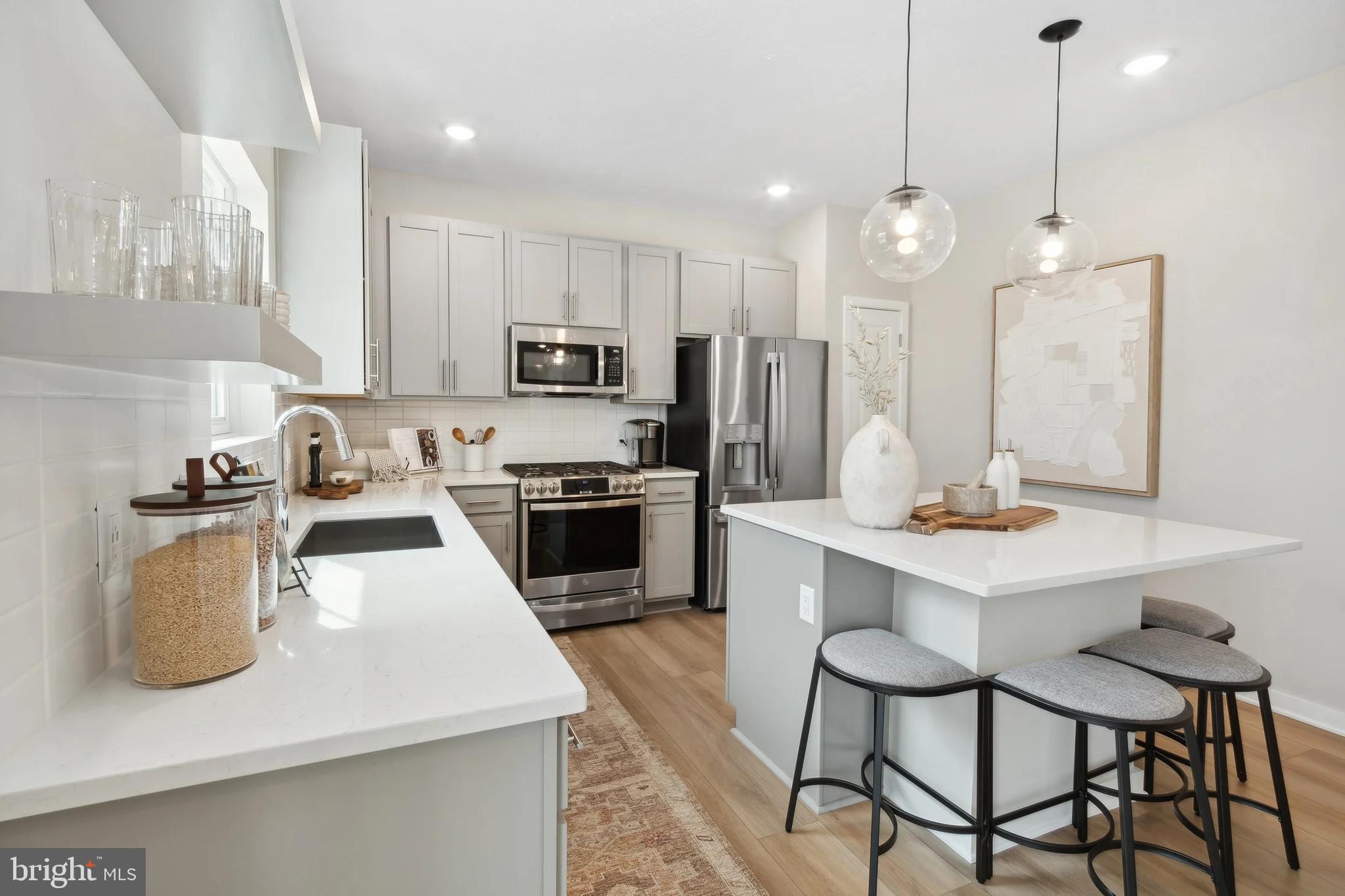 94 Thornton Avenue Ranson, WV 25438 - Photo 3 of 24 a kitchen with refrigerator a stove a sink and chairs