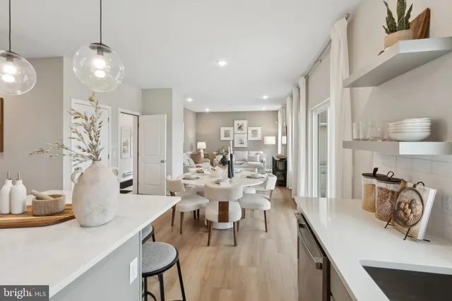 a view of a dining room and livingroom with furniture wooden floor a chandelier