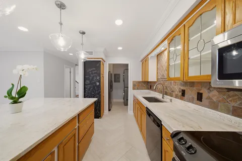 a kitchen with stainless steel appliances granite countertop a sink a stove and a wooden floors