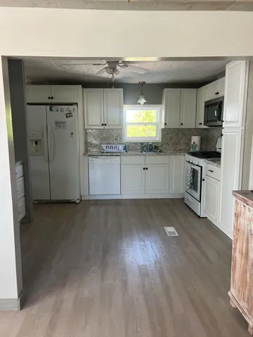 a kitchen with stainless steel appliances a refrigerator and wooden floor