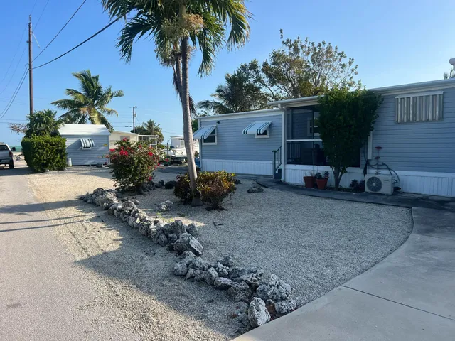 a backyard of a house with potted plants and large tree