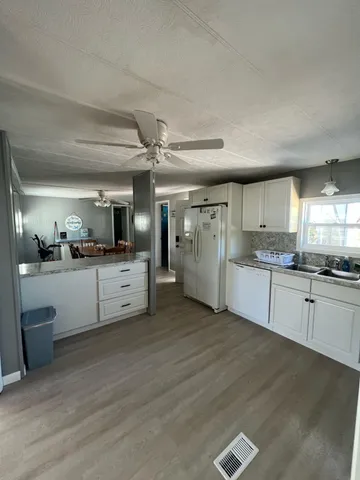 a large white kitchen with a stove a sink dishwasher and a refrigerator