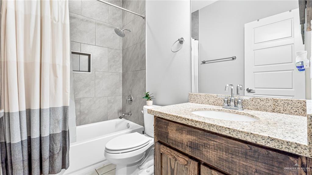 14208 Boykin Creek Road McAllen, TX 78504 - Photo 14 of 30 a bathroom with a granite countertop sink a toilet a mirror and shower