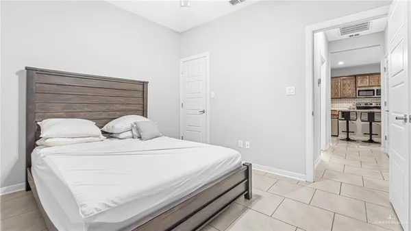 a white bed sitting in a bedroom next to a window