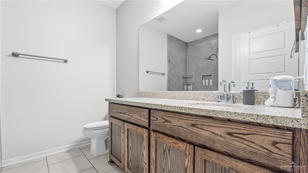 14208 Boykin Creek Road McAllen, TX 78504 - Photo 25 of 30 a spacious bathroom with a granite countertop sink and a mirror