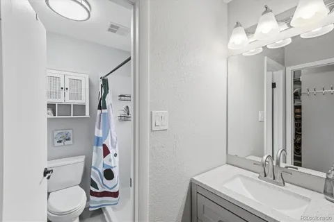 a bathroom with a sink vanity mirror and toilet