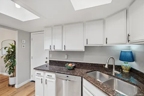 a kitchen with granite countertop a sink stainless steel appliances and cabinets