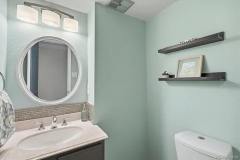 a bathroom with a sink mirror and toilet