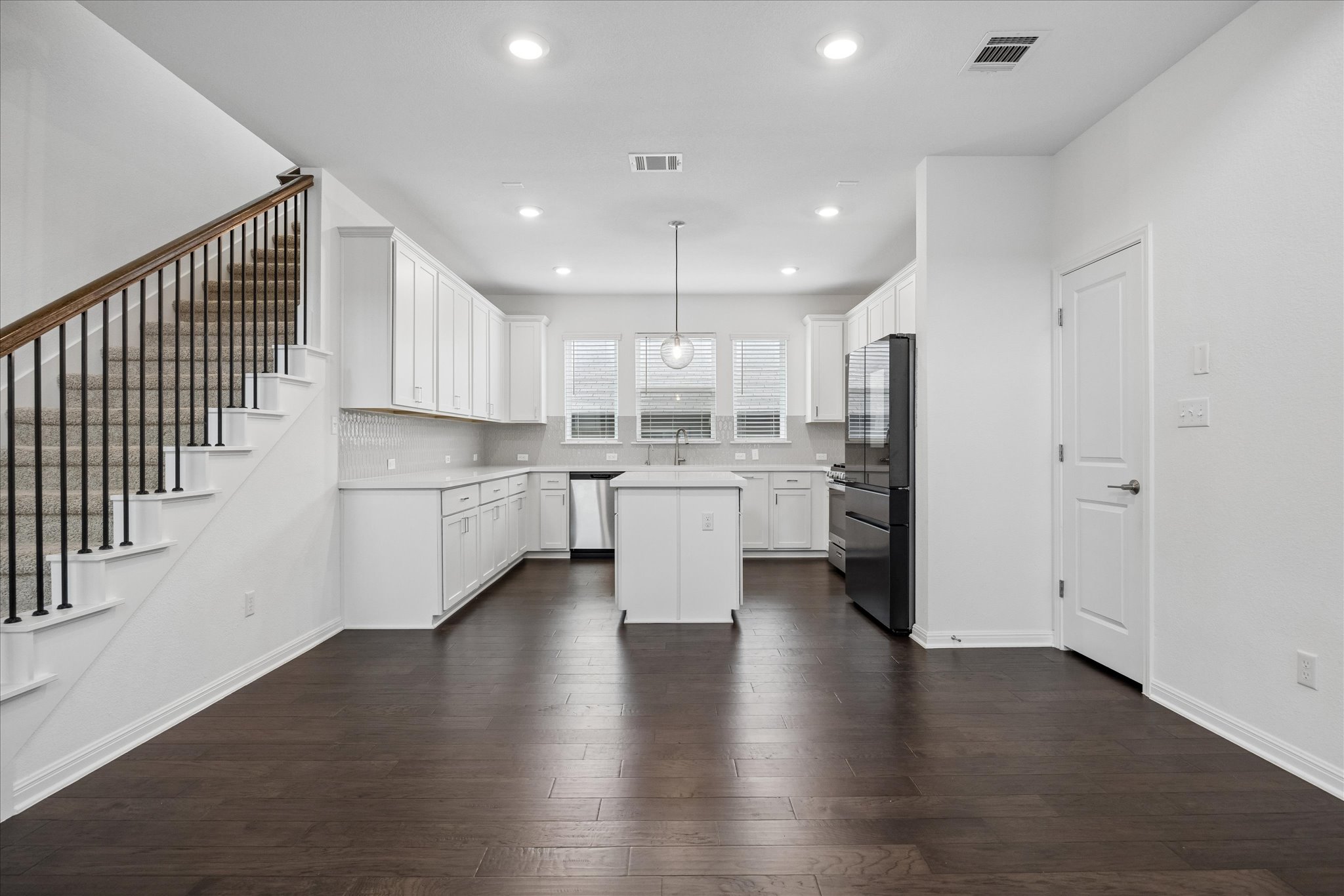 6407 Rounded Pebble Lane Buda, TX 78610 - Photo 9 of 32 Clean lines define this bright kitchen and living space, offering modern comforts and seamless flow.