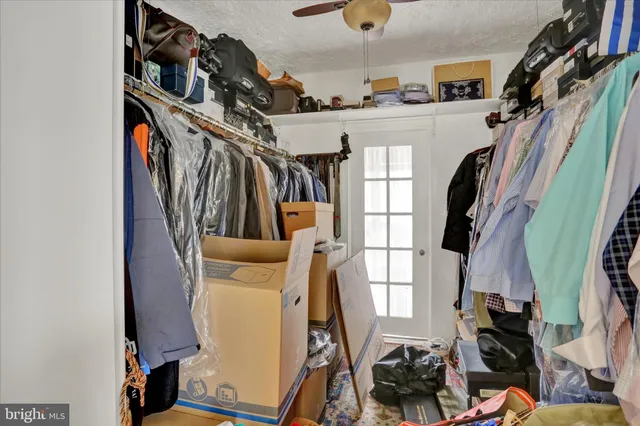 a view of walk in closet with clothes and shoes