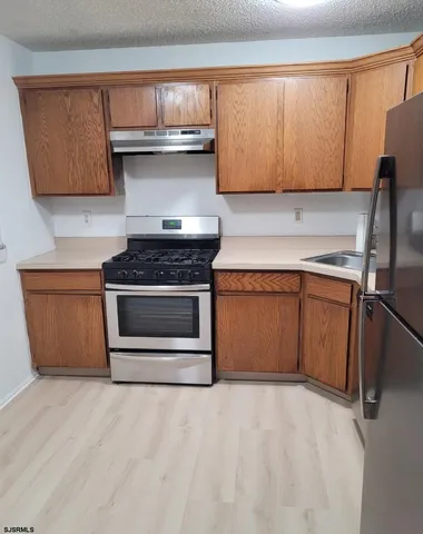 a kitchen with granite countertop stainless steel appliances and wooden cabinets