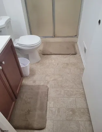 a bathroom with a toilet and a rug