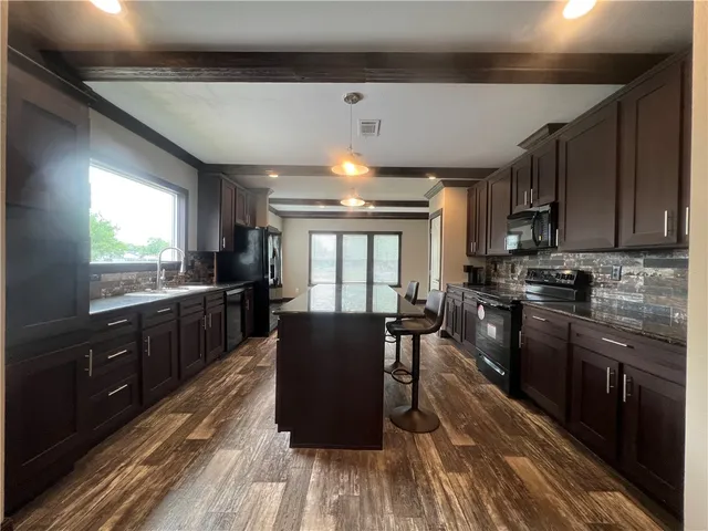 a large kitchen with lots of counter space a sink and appliances