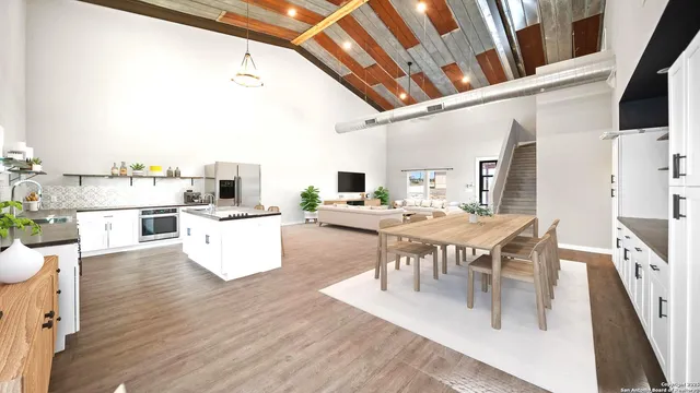 a large white kitchen with a large window and stainless steel appliances