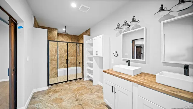 a spacious bathroom with a shower sink and mirror