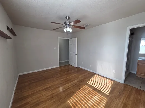 a view of empty room with wooden floor