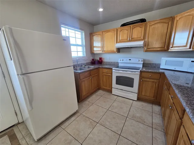 a kitchen with cabinets stainless steel appliances a sink and a window