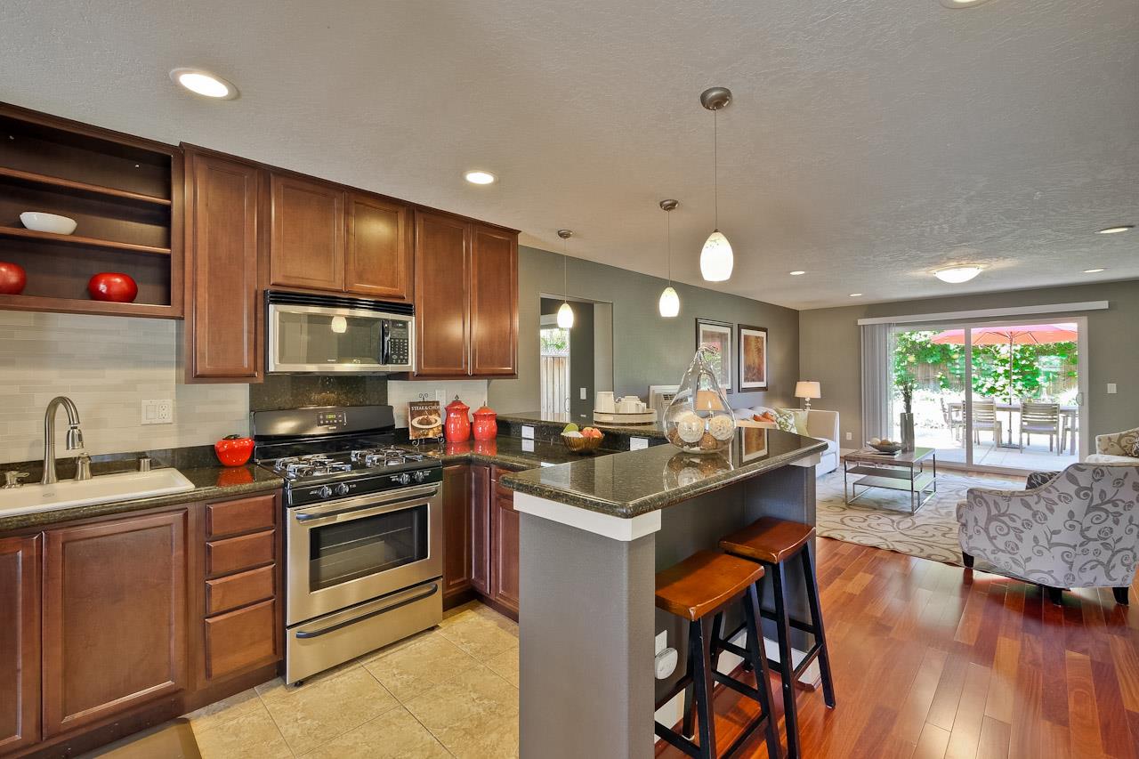 2002 West Middlefield Road, Unit 5 Mountain View, CA 94043 - Photo 8 of 24 a kitchen with stainless steel appliances kitchen island granite countertop a sink a stove a dining table and chairs
