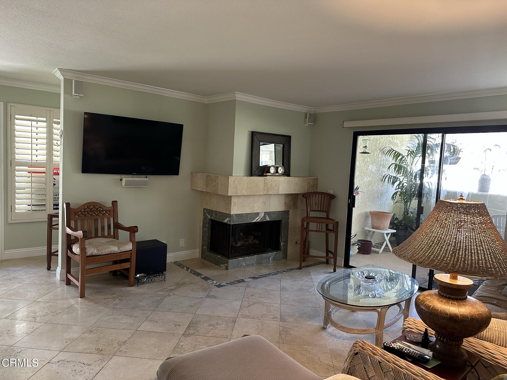 4475 Antigua Way Oxnard, CA 93035 - Photo 4 of 31 a living room with furniture a flat screen tv and a fireplace