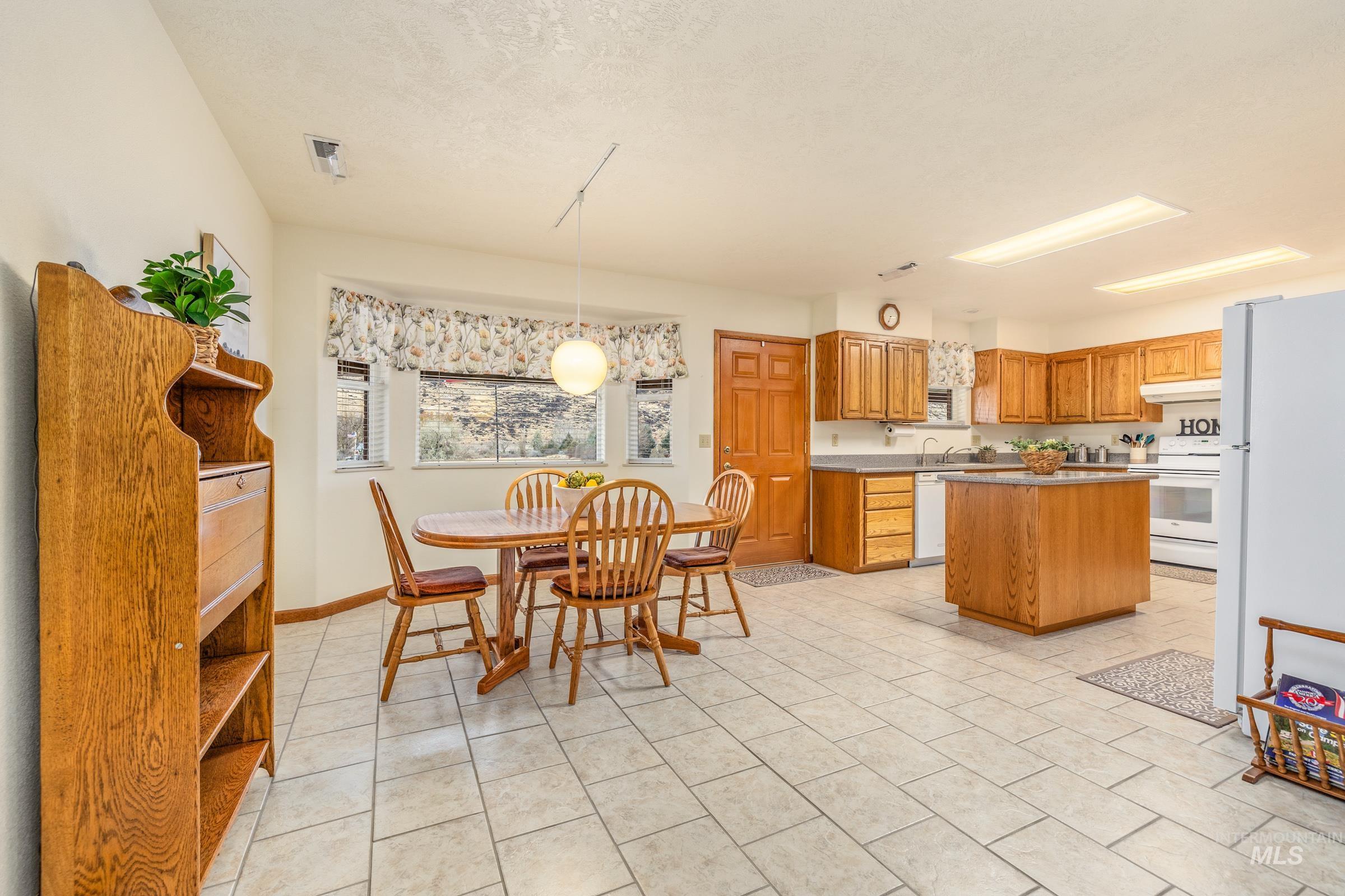 10514 Airpark Loop Road Melba, ID 83641 - Photo 12 of 48 Dining area featuring a textured ceiling and light tile patterned flooring