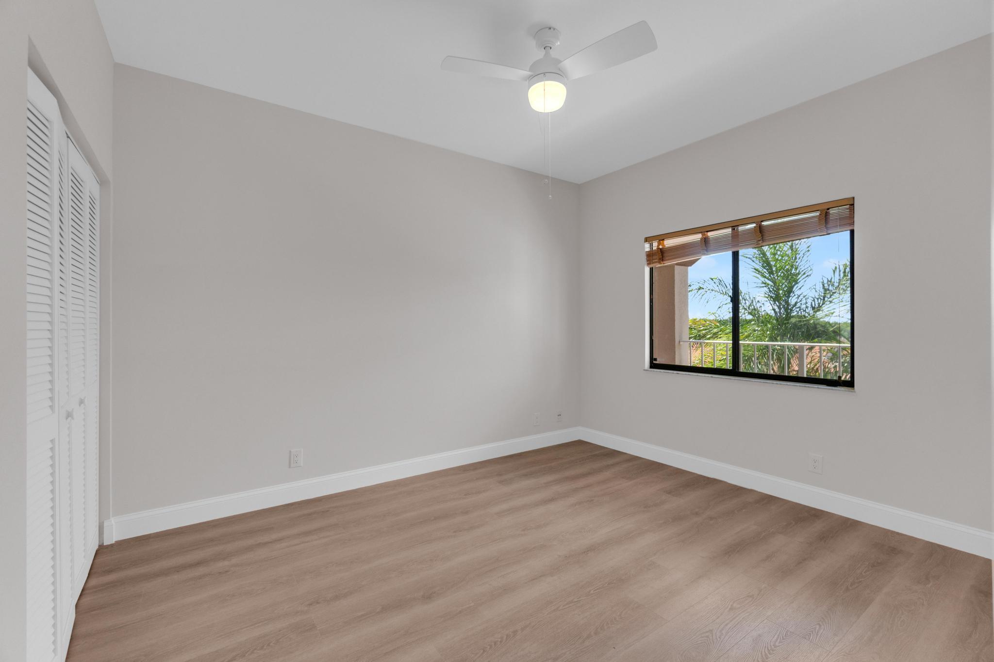 6241 Pointe Regal Circle, Unit 402 Delray Beach, FL 33484 - Photo 12 of 23 wooden floor in an empty room with a window