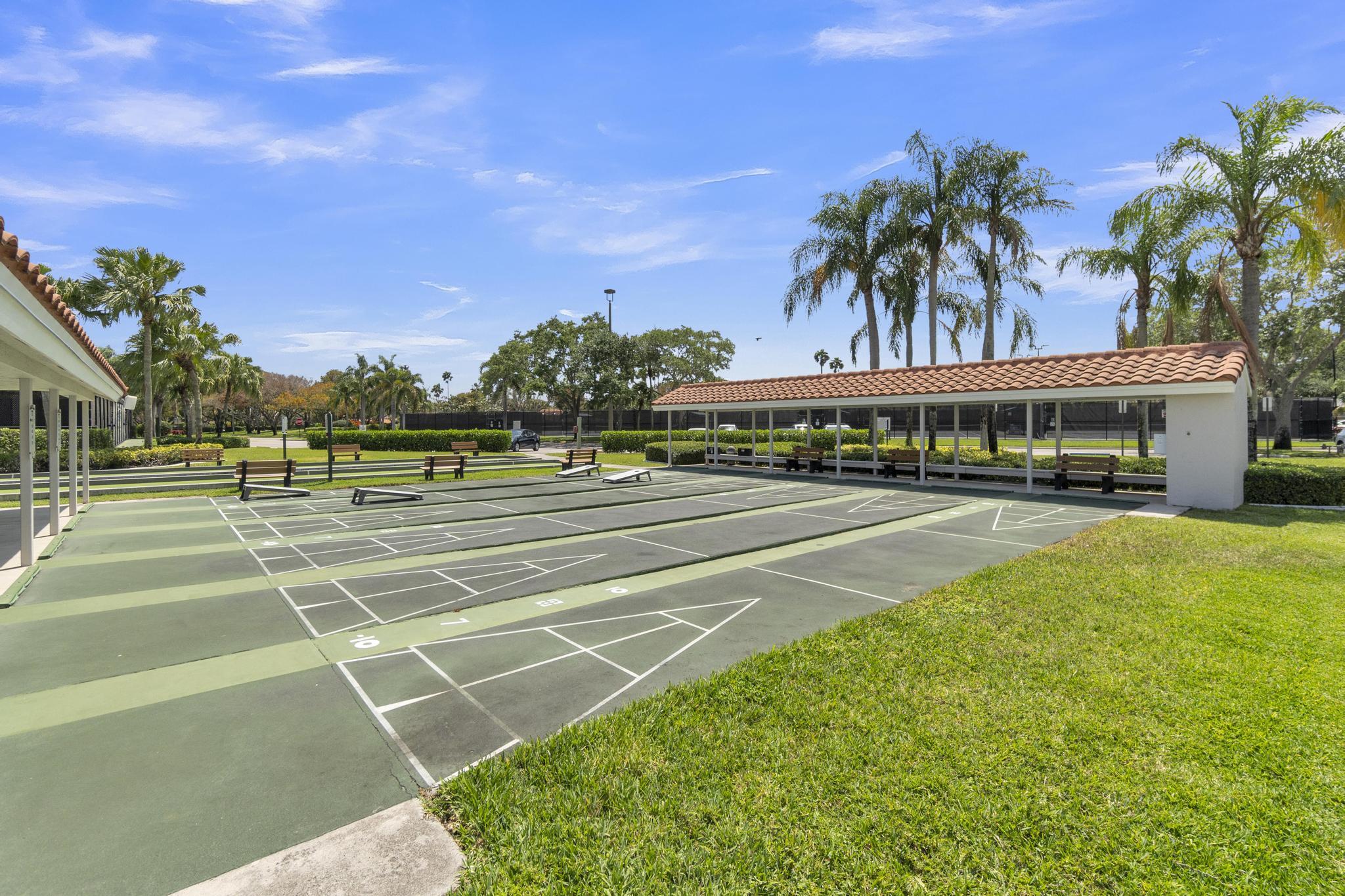 6241 Pointe Regal Circle, Unit 402 Delray Beach, FL 33484 - Photo 20 of 23 a view of a tennis ground with large trees