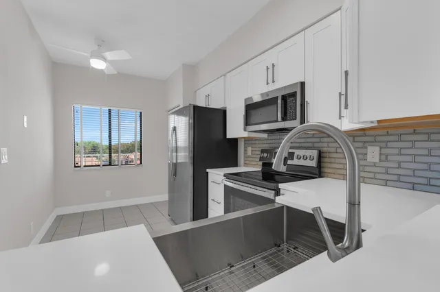 a kitchen with stainless steel appliances a refrigerator a stove a microwave and sink