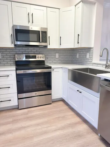 a kitchen with stainless steel appliances a stove microwave and sink