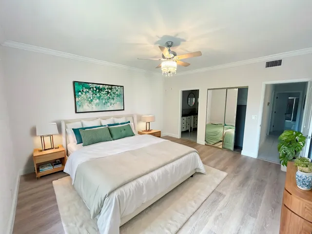 a spacious bedroom with a bed and a chandelier