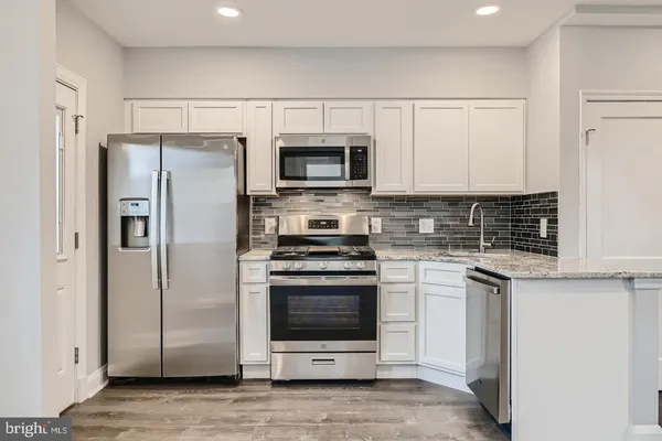 a kitchen with stainless steel appliances a stove a sink and a microwave