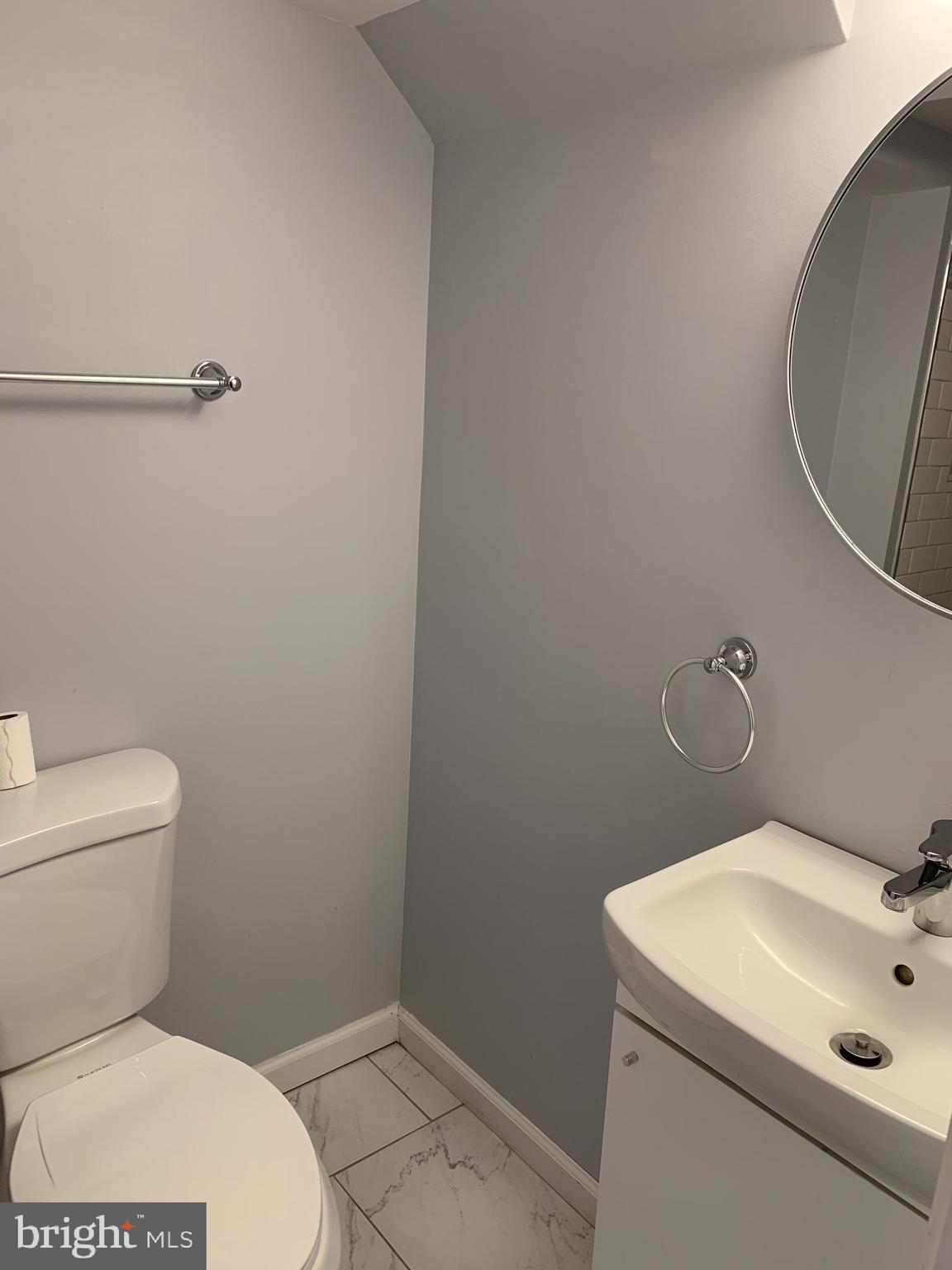 4429 Newport Avenue Baltimore, MD 21211 - Photo 13 of 17 a bathroom with a sink a toilet and a mirror
